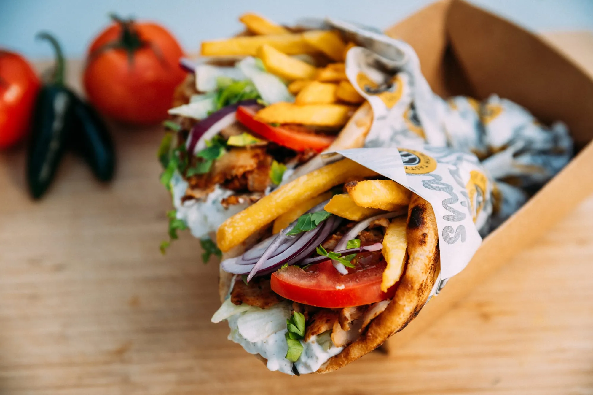Kyckling gyro i pita med pommes, tzatziki, tomat och rödlök